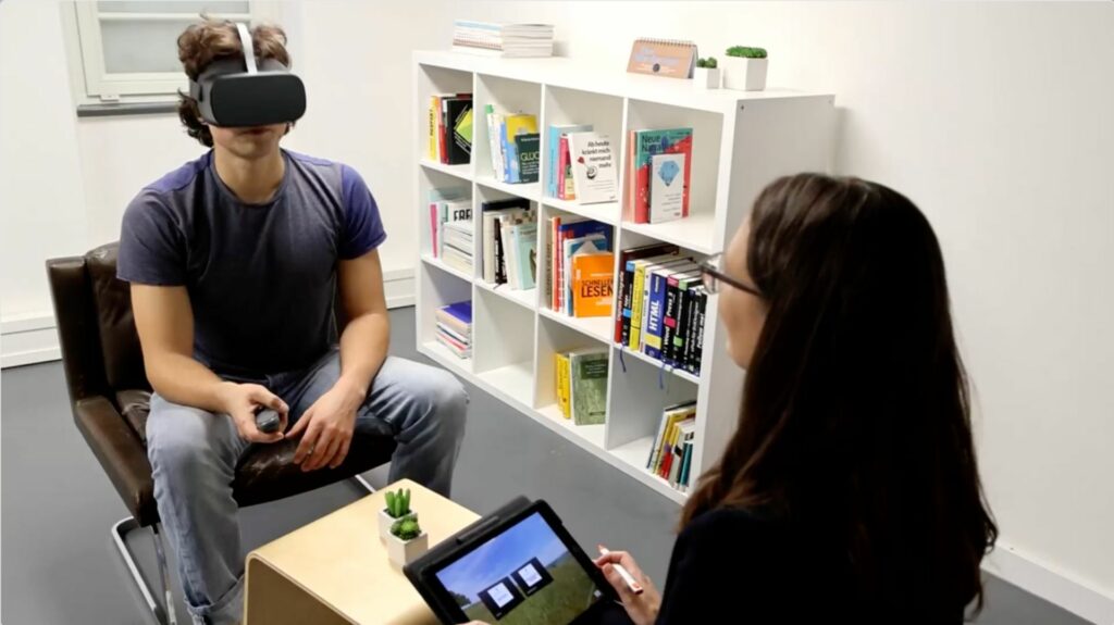 VR in der Psychotherapie Therapeutin begleitet jungen Mann durch eine VR Behandlung
